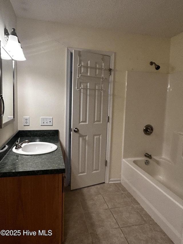 bathroom featuring tile patterned flooring, vanity, and washtub / shower combination