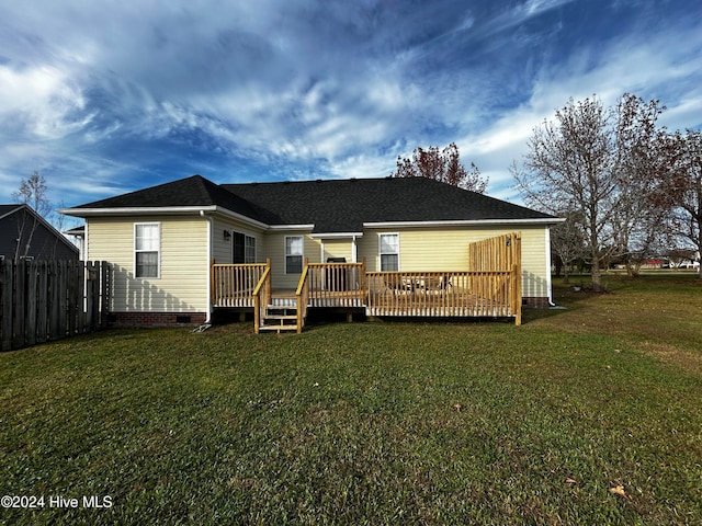 back of house featuring a lawn and a deck