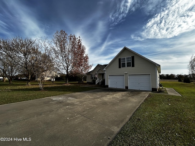 view of side of property featuring a lawn and a garage