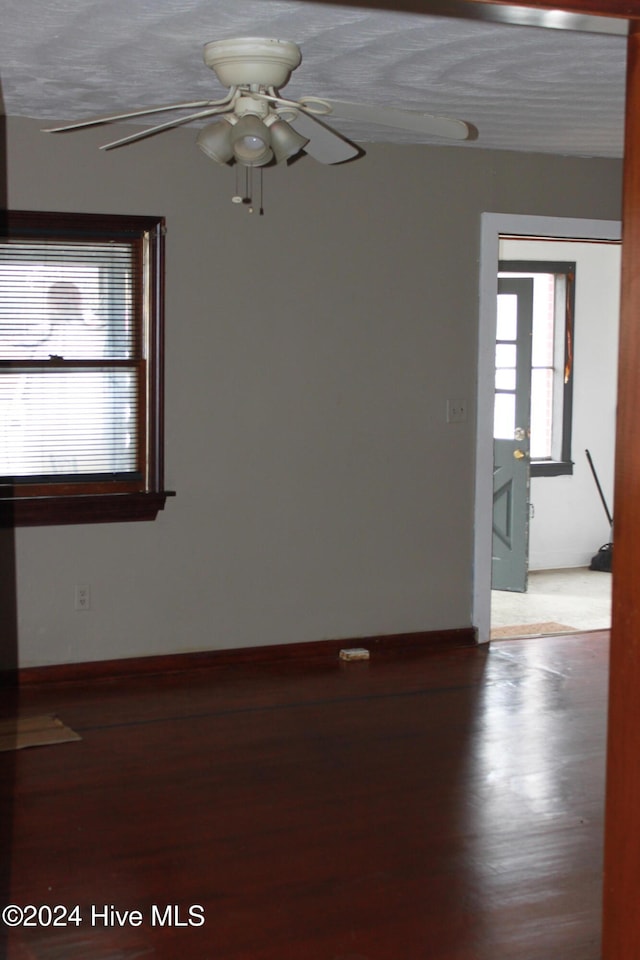 empty room with hardwood / wood-style floors, ceiling fan, and a textured ceiling