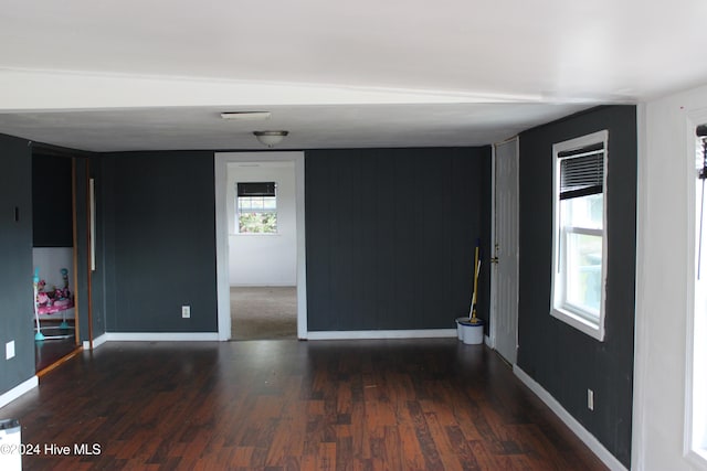 unfurnished room with dark wood-type flooring