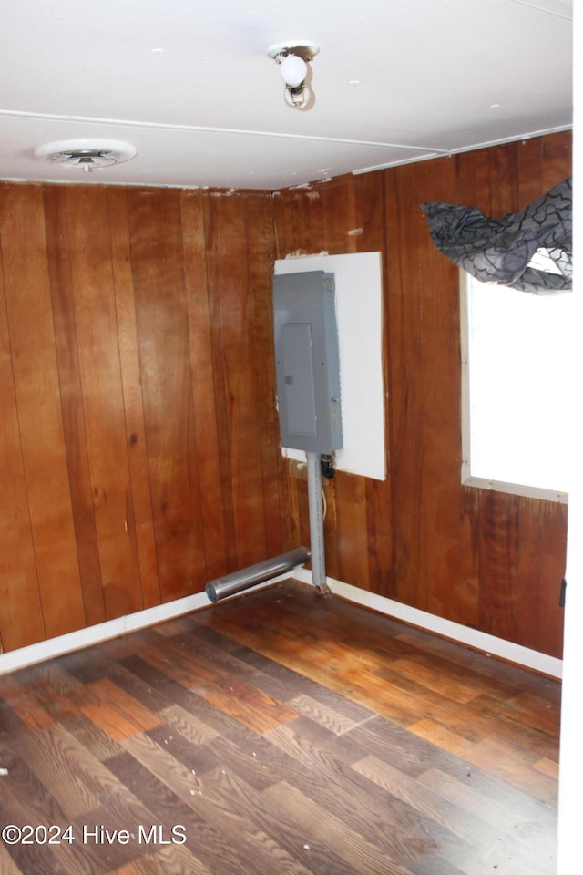 empty room featuring dark hardwood / wood-style floors and wooden walls