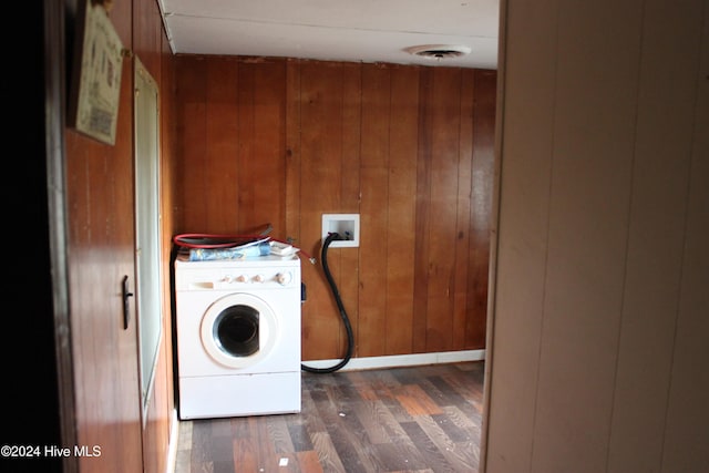 laundry area featuring dark hardwood / wood-style floors, wood walls, and washer / dryer