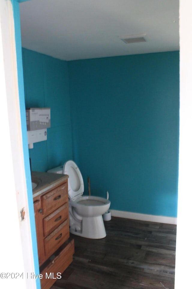 bathroom with vanity, toilet, and wood-type flooring