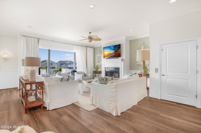 living room featuring ceiling fan with notable chandelier and light wood-type flooring