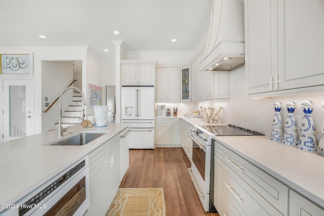 kitchen featuring pendant lighting, dishwasher, sink, light wood-type flooring, and an island with sink