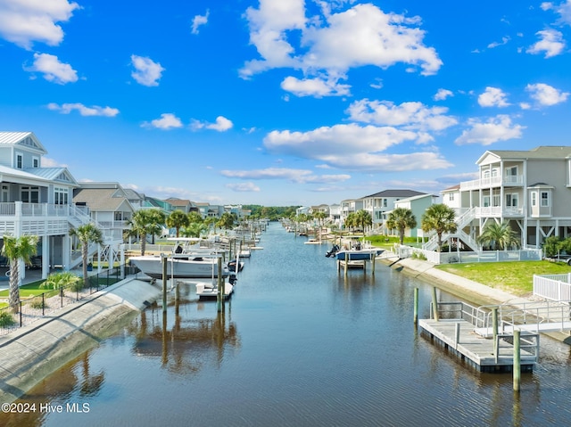 back of property featuring a yard, a balcony, and a water view