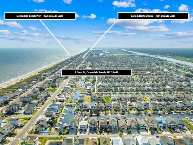 drone / aerial view featuring a water view and a view of the beach