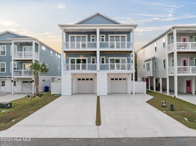 coastal home with a garage, concrete driveway, board and batten siding, and a front yard