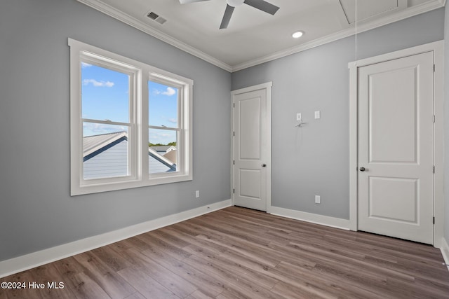 unfurnished bedroom featuring wood-type flooring, ceiling fan, and crown molding