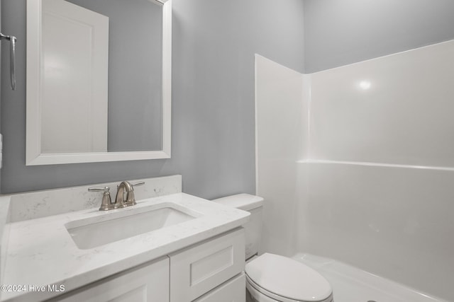 bathroom with a shower, vanity, and toilet