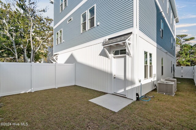 view of side of home featuring a lawn and central air condition unit