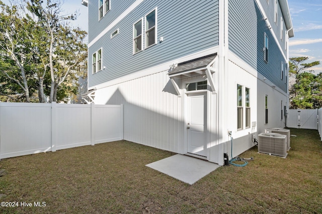 view of property exterior with cooling unit and a lawn