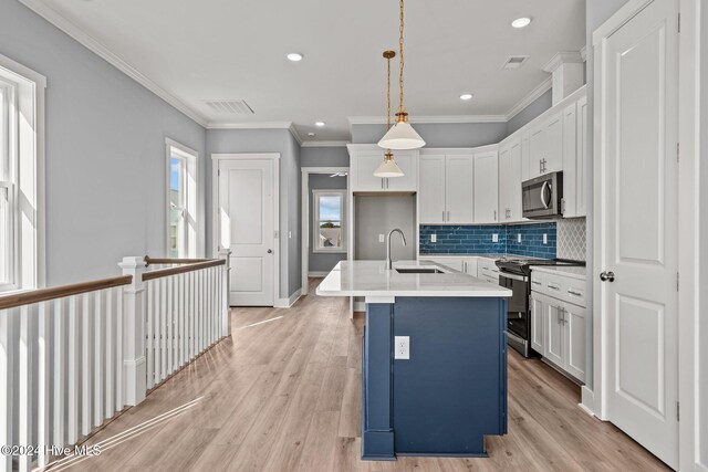 kitchen with stainless steel appliances, white cabinetry, sink, and hanging light fixtures