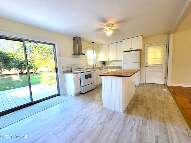 kitchen featuring butcher block counters, white cabinetry, wall chimney exhaust hood, and white appliances