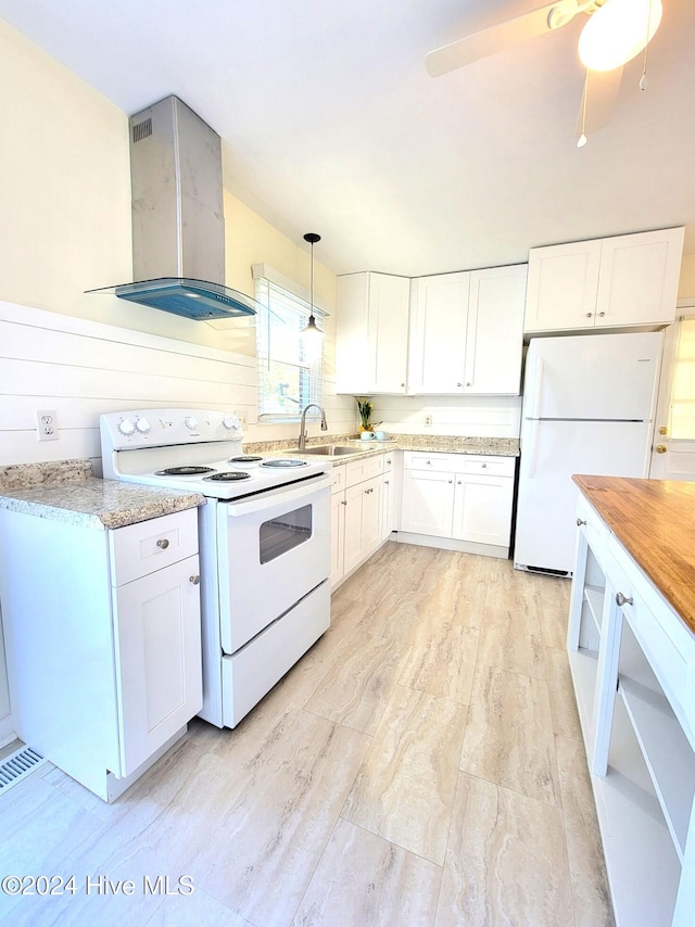 kitchen featuring pendant lighting, white appliances, white cabinetry, and wall chimney range hood