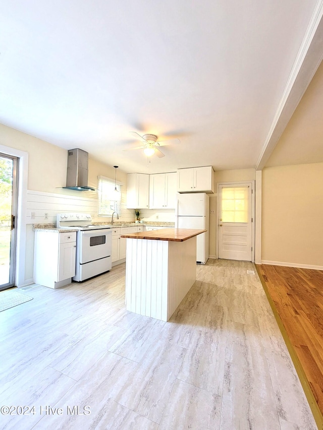 kitchen featuring wall chimney exhaust hood, white appliances, pendant lighting, light hardwood / wood-style flooring, and white cabinetry