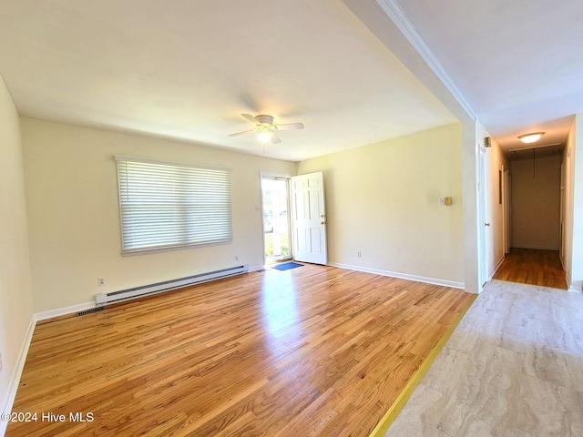 spare room featuring ceiling fan, light wood-type flooring, and baseboard heating