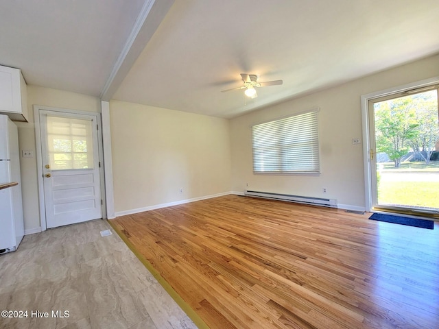 interior space with ceiling fan, light hardwood / wood-style floors, and a baseboard heating unit