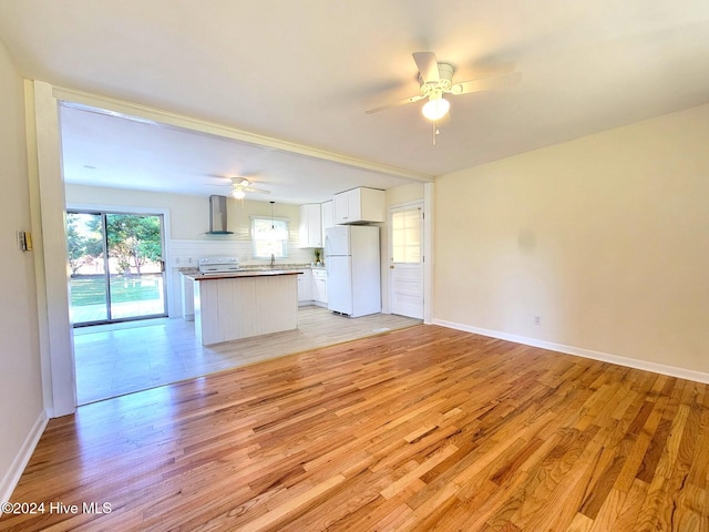 unfurnished living room featuring ceiling fan, sink, and light wood-type flooring