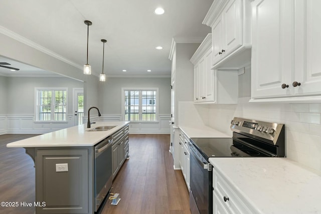 kitchen with dark wood-style flooring, white cabinetry, a center island with sink, appliances with stainless steel finishes, and a sink