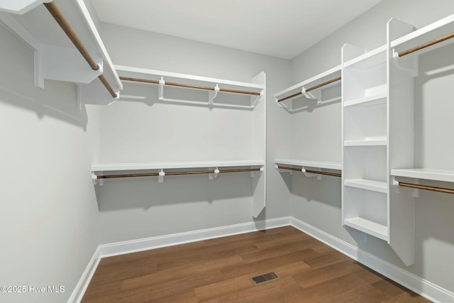 spacious closet featuring dark wood finished floors and visible vents
