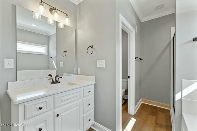 bathroom featuring ornamental molding, visible vents, toilet, wood finished floors, and baseboards