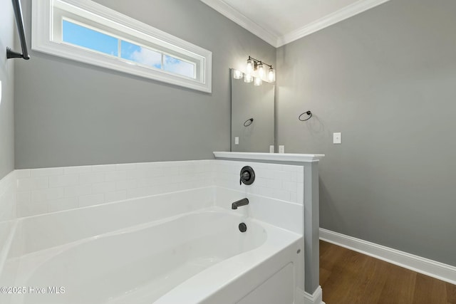 bathroom featuring baseboards, a garden tub, crown molding, and wood finished floors