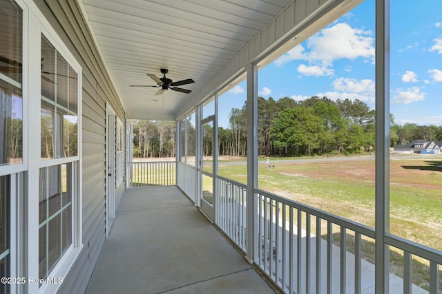 unfurnished sunroom with ceiling fan