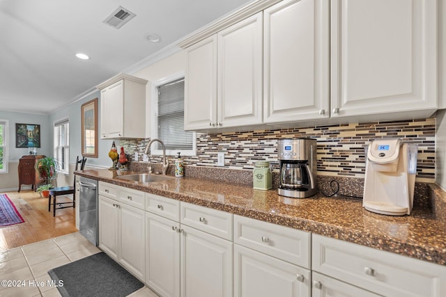 kitchen featuring stainless steel dishwasher, white cabinetry, crown molding, and sink