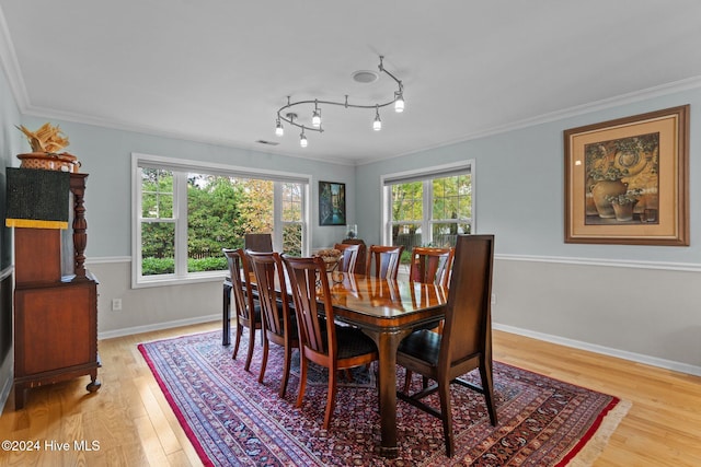 dining area with hardwood / wood-style floors, plenty of natural light, and ornamental molding