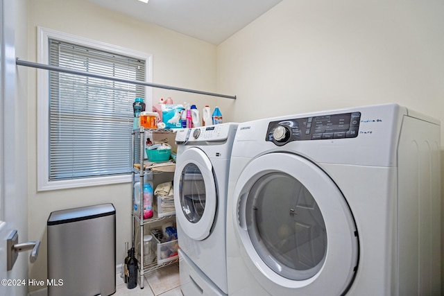 clothes washing area with washer and clothes dryer and light tile patterned floors