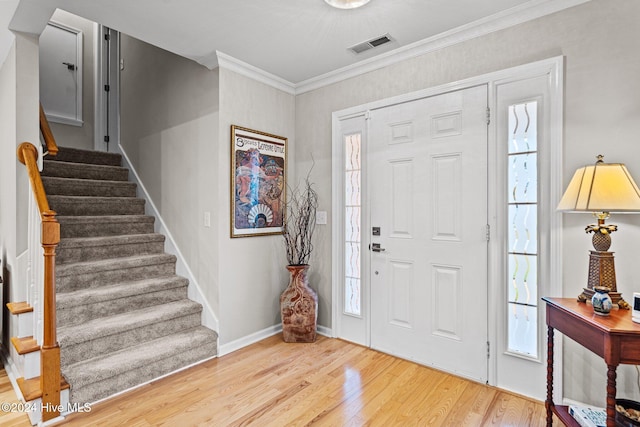 entrance foyer featuring crown molding and light wood-type flooring