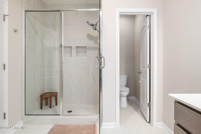 bathroom featuring vanity, an enclosed shower, and toilet