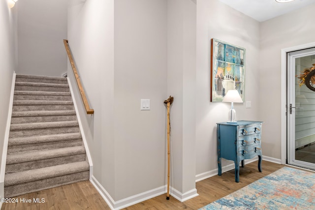 stairs featuring hardwood / wood-style floors