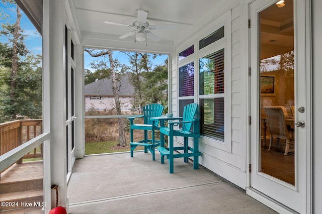 unfurnished sunroom featuring ceiling fan