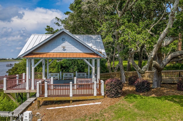 view of property's community with a gazebo and a deck with water view