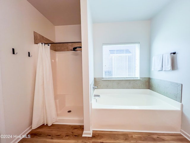 bathroom featuring plus walk in shower and hardwood / wood-style flooring