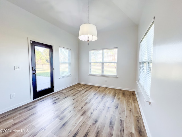 unfurnished room featuring light wood-type flooring and lofted ceiling