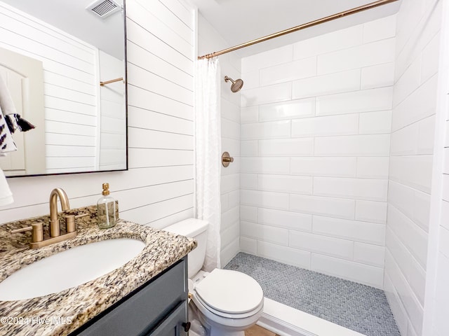 bathroom featuring vanity, toilet, curtained shower, and wooden walls