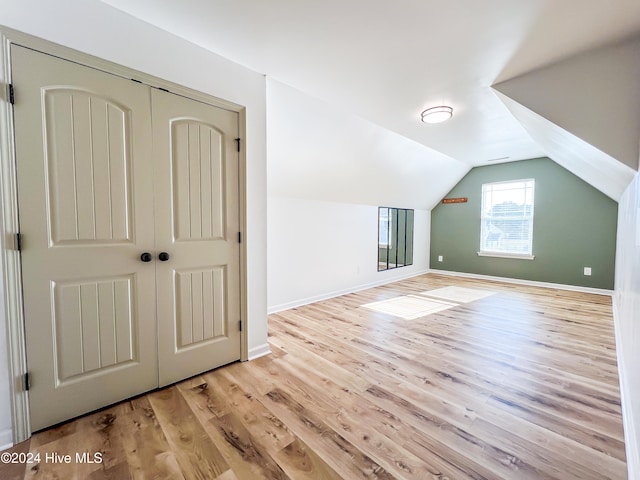 bonus room with light hardwood / wood-style floors and vaulted ceiling