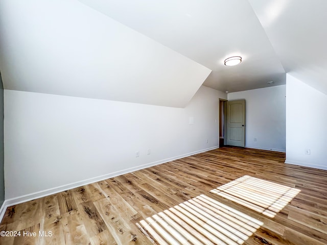 additional living space featuring hardwood / wood-style floors and lofted ceiling