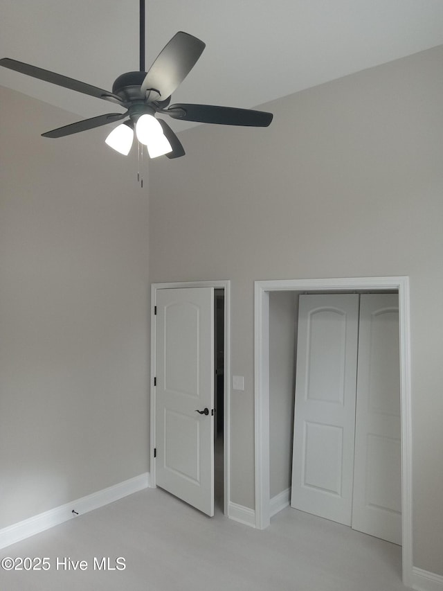 unfurnished bedroom featuring ceiling fan and a closet