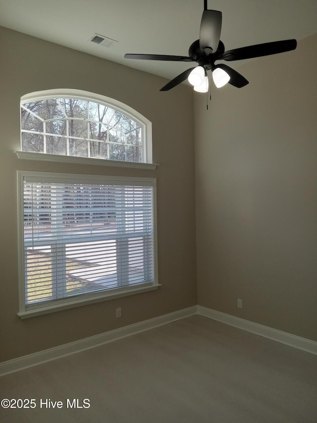 spare room featuring visible vents, baseboards, and ceiling fan