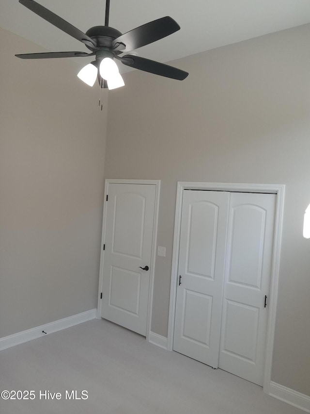 unfurnished bedroom featuring a closet, a ceiling fan, and baseboards