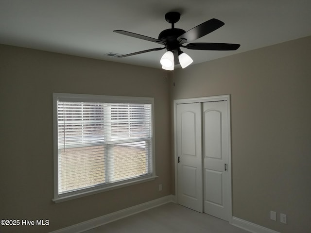 unfurnished bedroom featuring a closet, a ceiling fan, and baseboards