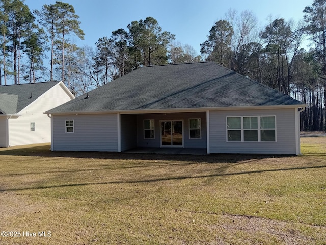 rear view of property featuring a yard and a shingled roof