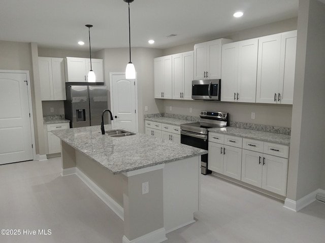 kitchen with sink, stainless steel appliances, an island with sink, white cabinets, and decorative light fixtures