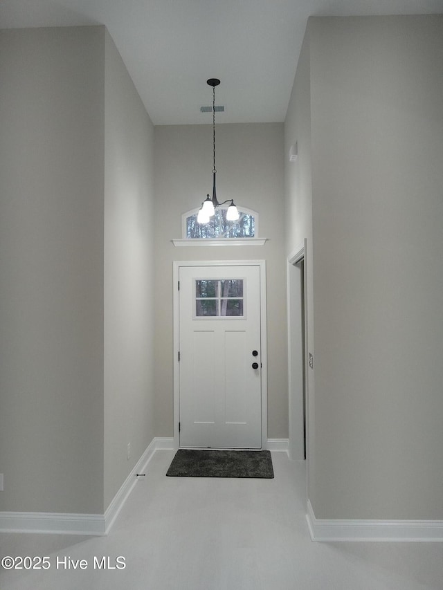 entryway with visible vents, baseboards, and a towering ceiling