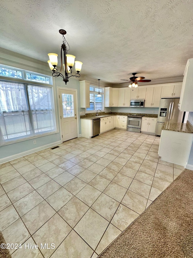 kitchen featuring pendant lighting, light tile patterned floors, white cabinetry, and appliances with stainless steel finishes